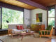 a mid century modern living room with exposed beam ceiling and a heywood wakefield living room set