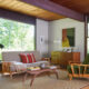 a mid century modern living room with exposed beam ceiling and a heywood wakefield living room set