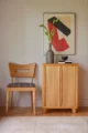a wooden chair and a small cabinet both in a blonde wood color