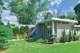 the side of a mid century modern house with corner windows that span from floor to ceiling. the flat roof is a mid century modern highlight. 
