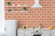 Pink, yellow and red geometric Mid-Century Modern Wallpaper covers the back wall of a retro kitchen.
