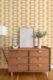 A Mid-Century Modern sideboard with a geometric yellow and tan Mid-Century Modern Wallpaper background.