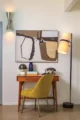 Mid-Century Modern home office with a wood desk, yellow chair, abstract artwork, vintage telephone and floor lamp.