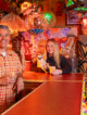 a man and woman in a tiki room bar with tiki drinks in hand