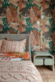 a bedroom with pink safari style wallpaper